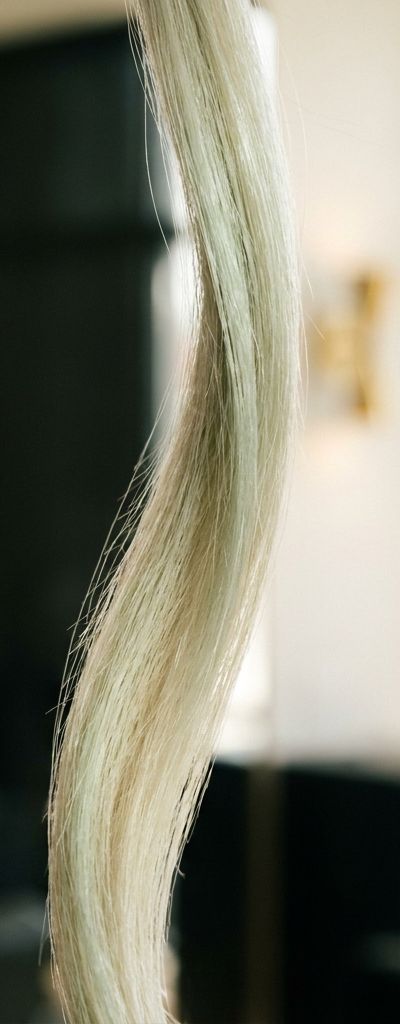 Mechón de cabello rubio decolorado con tonos verdosos antes y después de neutralización