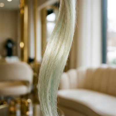 Bleached blonde hair strand with greenish tones before and after neutralization