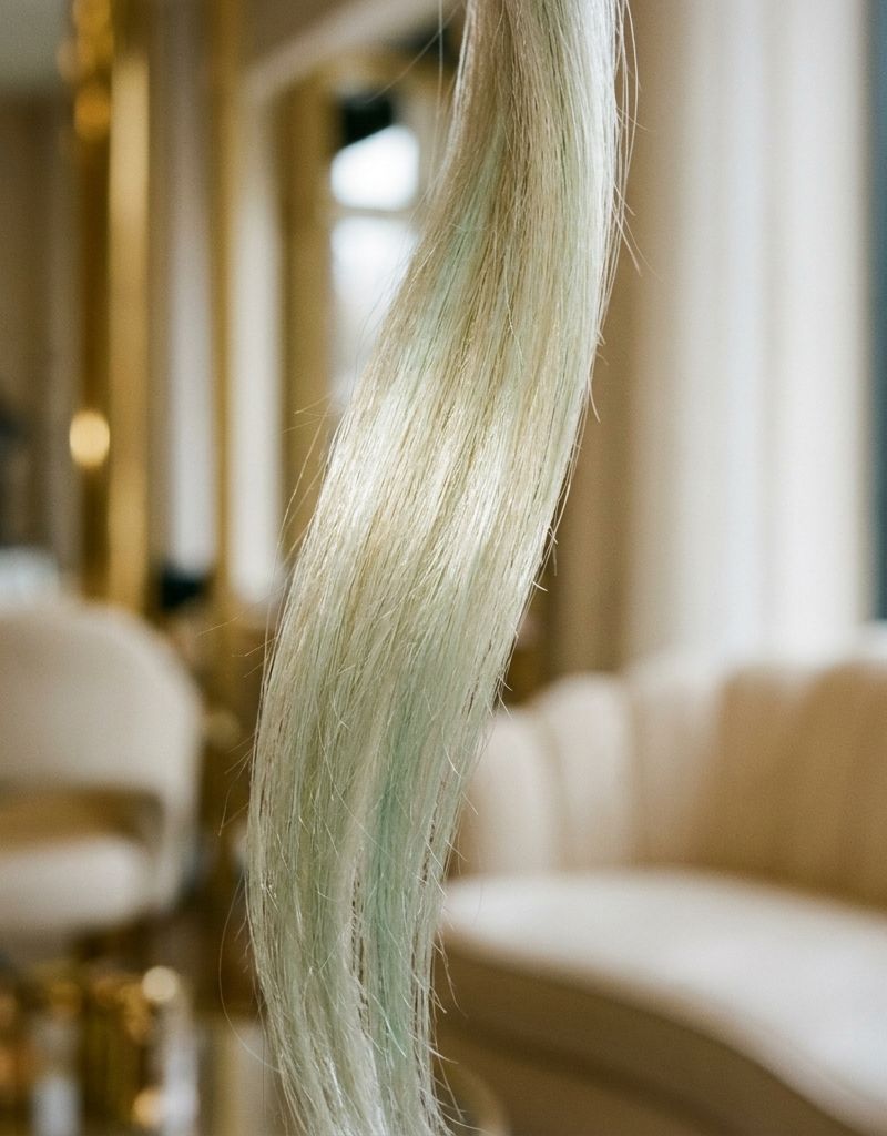 Bleached blonde hair strand with greenish tones before and after neutralization