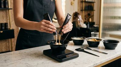Colorista profissional misturando tinta com oxidante em tigela de aplicação sobre a mesa de trabalho do salão