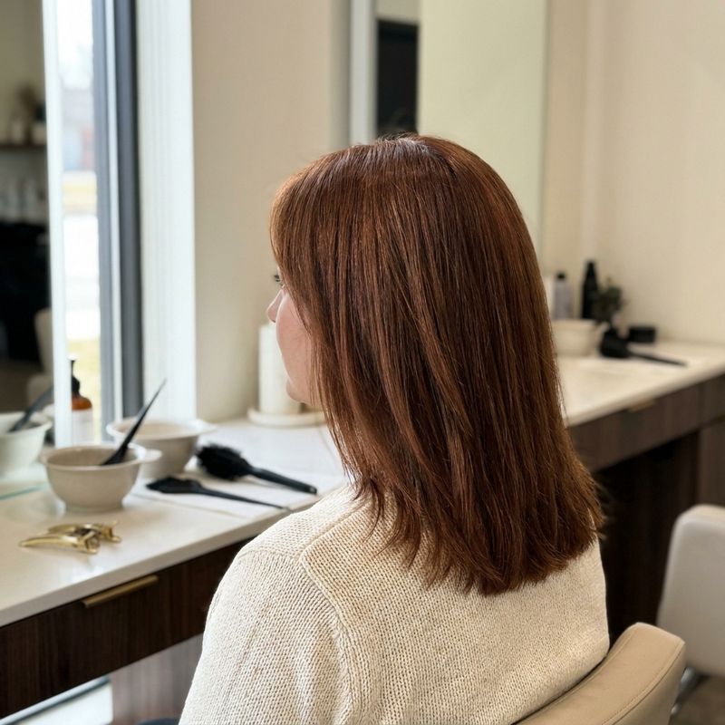 Cabelo auburn castanho avermelhado elegante e natural, visto de costas num salão com luz de janela