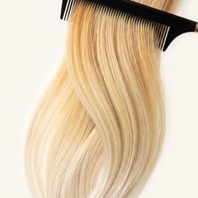 Cabelo loiro com fundo de descoloração desigual em raiz, meios e pontas, sobre fundo claro de estúdio