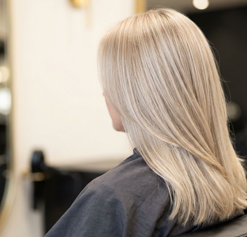 Cool satin blonde hair in a champagne pearl tone after well-resolved toning, velvety finish under soft salon light