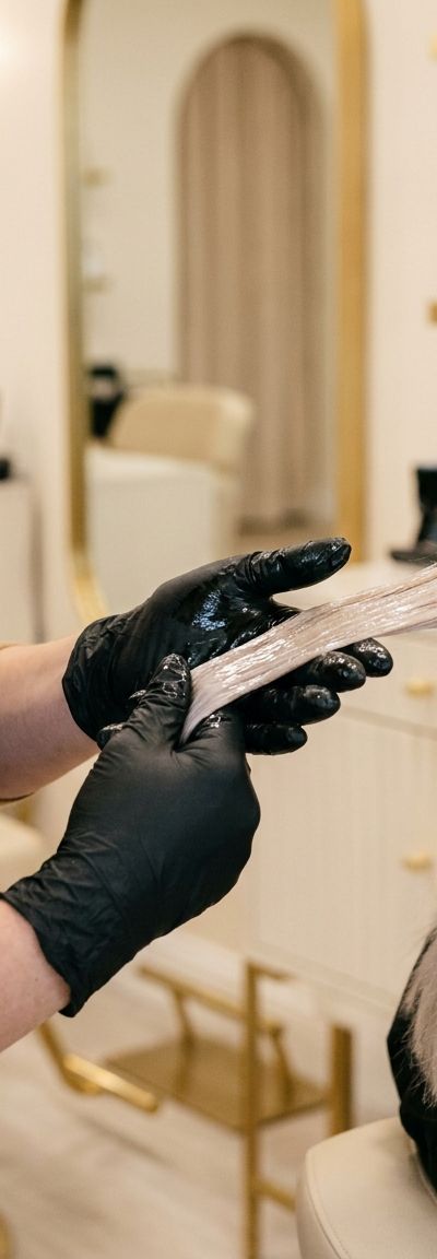 Colorist sealing the cuticle of cool blonde hair in a salon before summer